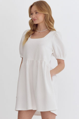 Woman wearing an Entro white mini dress square neckline boutique