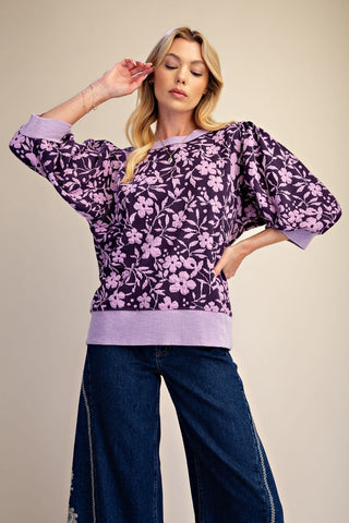 Woman wearing an Easel purple and lavender textured knit floral top. Style #ET30249.