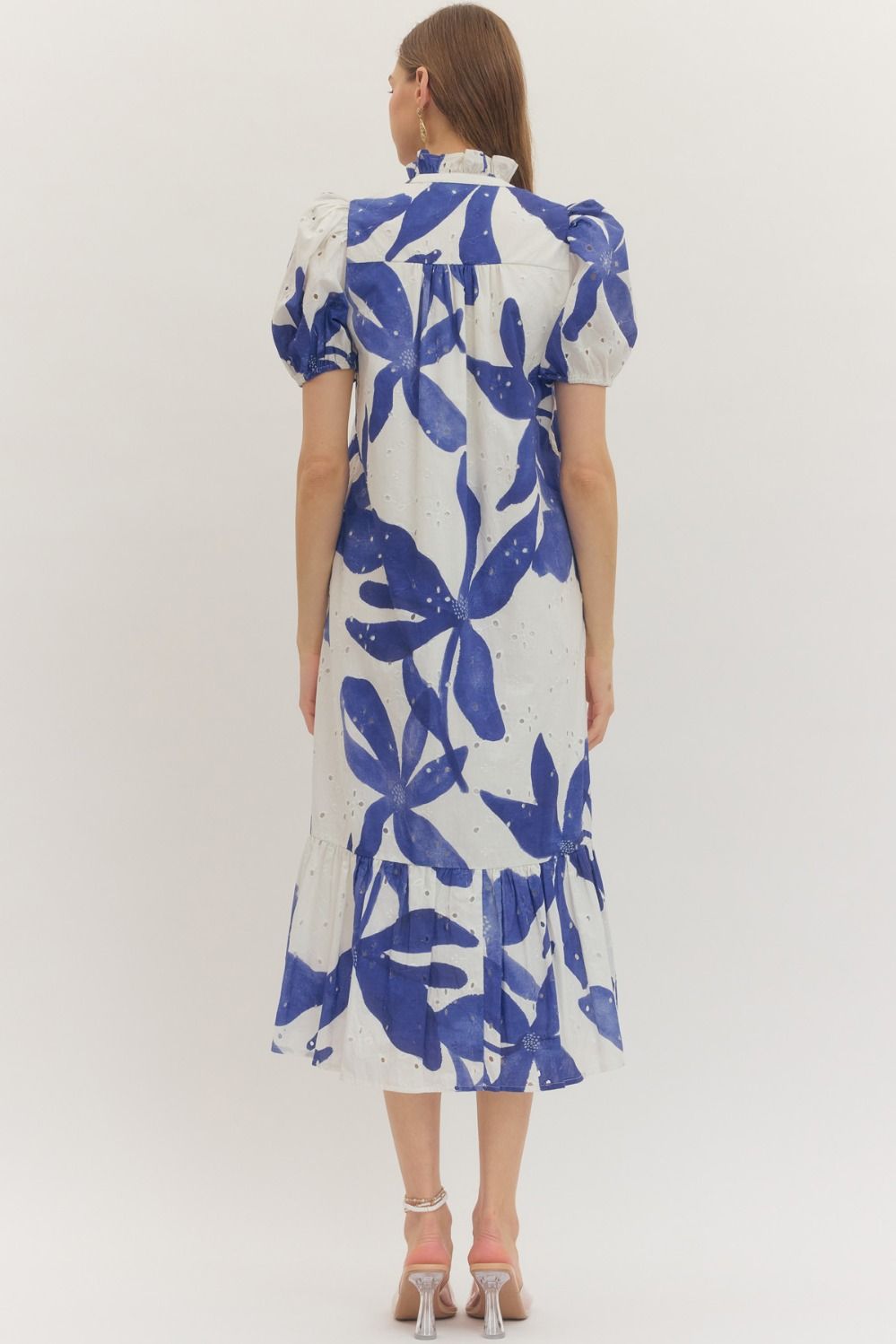 Woman wearing an Entro blue and white floral dress on a white background rear view