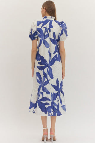 Woman wearing an Entro blue and white floral dress on a white background rear view