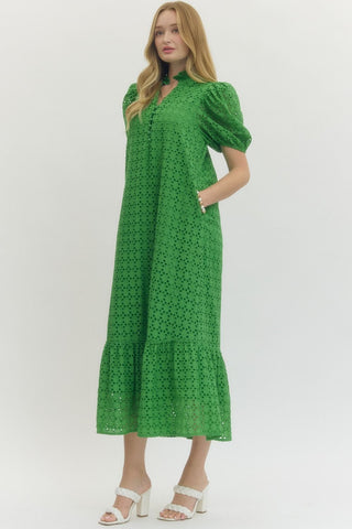 Woman wearing a green dress with puff sleeves on a white background