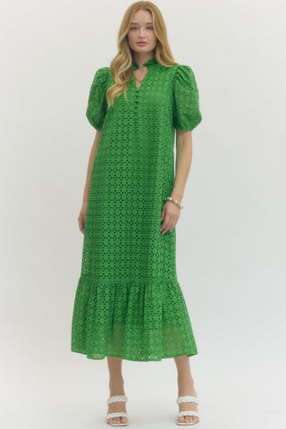 Woman wearing an Entro green eyelet lace dress with puff sleeves on a white background