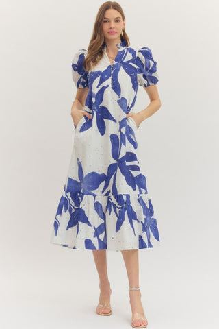 Woman wearing a white dress with blue floral pattern on a white background