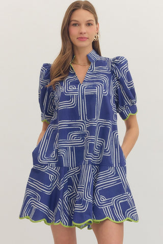 Woman wearing an Entro blue and white patterned dress on a plain background
