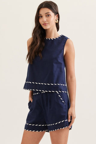 Woman wearing an Entro navy blue sleeveless short set