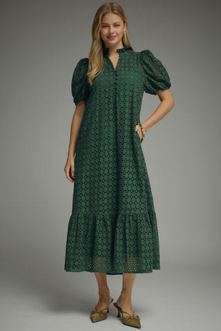 Woman wearing an forest green eyelet midi dress with puff sleeves again
