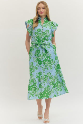 Woman wearing an Entro eyelet green and blue floral dress on a white background