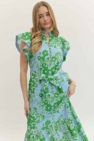 Woman wearing a green and blue floral dress on a white background