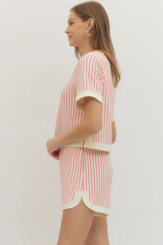 Woman wearing a pink and white striped short set with a side view