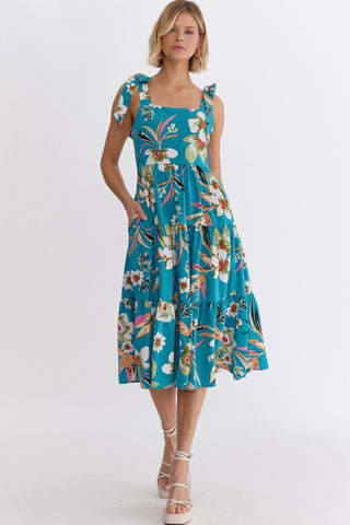 Woman wearing an Entro blue floral dress with ties at shoulders