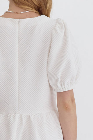 White textured dress with puff sleeves on a white background closeup back view