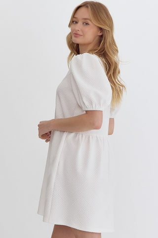 Woman wearing an Entro white square neckline mini dress side view