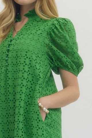 Green lace dress worn by a person on a white background closeup