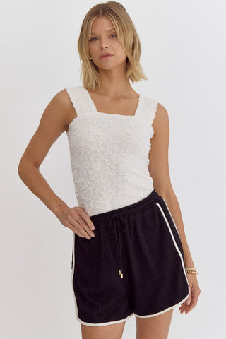Full view of Entro brand black shorts with white stripe styles woth white top