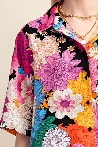 Colorful floral explosion patterned shirt by Gigio closeup with a neutral background
