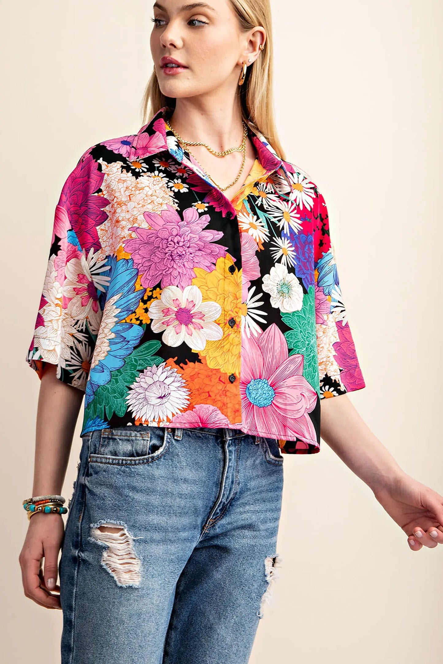 Woman wearing a colorful cropped pink short sleeve floral shirt from Gigio and jeans