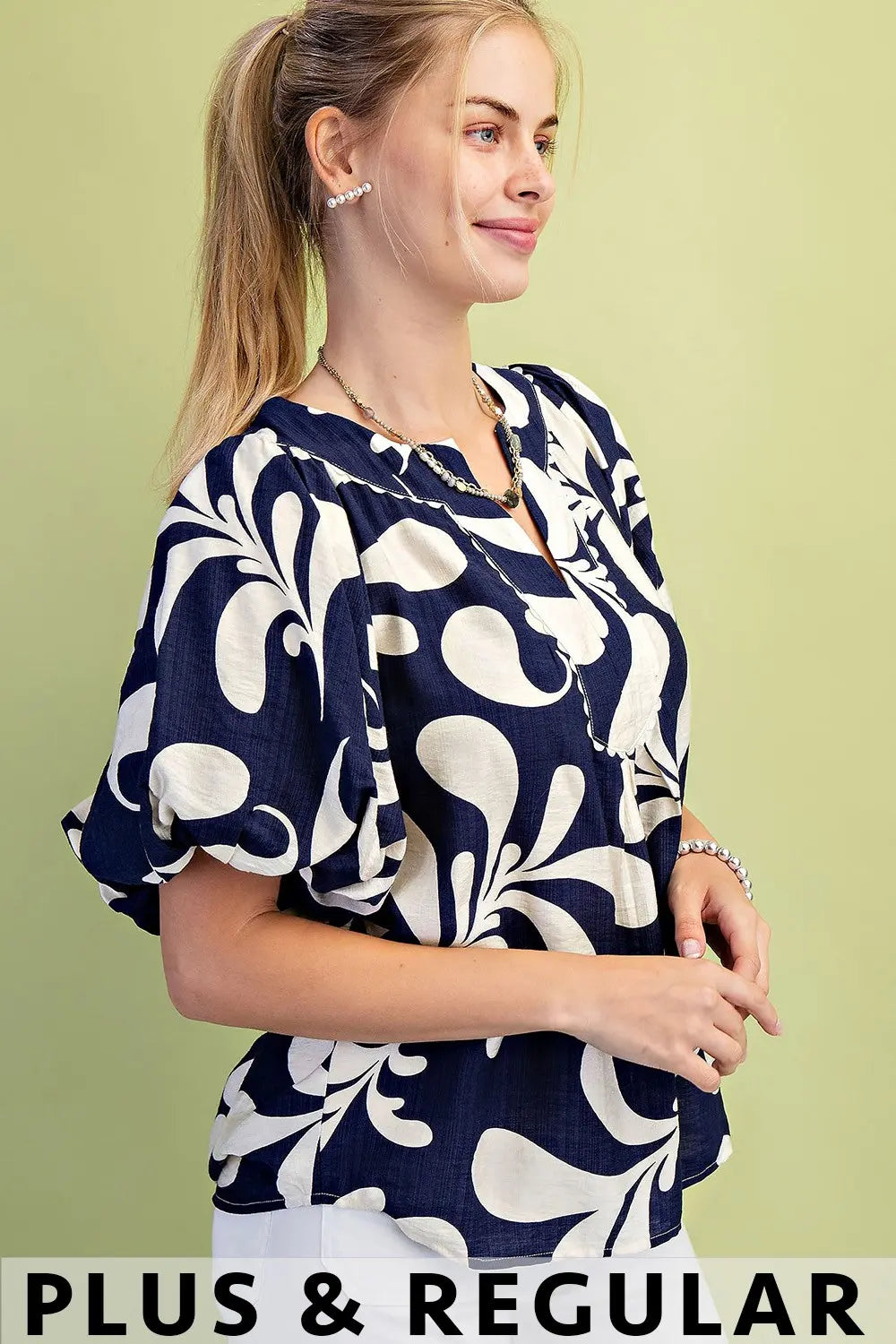 Gigio navy and off white patterned blouse against a light green background