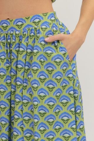 Green and blue patterned Entro skirt closeup view with hand in side pocket