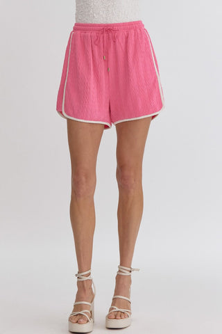 Pink textured fabric shorts with white trim by Entro