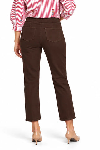 A person shown from the back wearing Tru Luxe Jeans dark brown cropped pants, a red-and-white striped blouse, and nude heels against a clean white studio background.