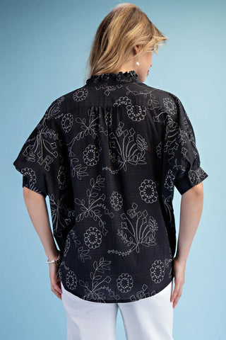 Woman wearing a Gigio black and white floral patterned blouse rear view