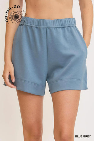 Umgee blue gray shorts worn by a person on a beige background