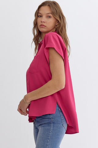 Woman wearing a bright pink top and blue jeans on a white background