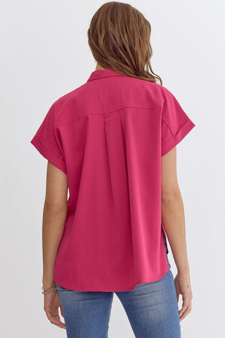 Person wearing a bright pink shirt and blue jeans on a white background