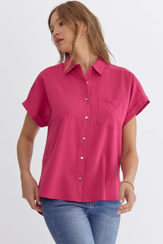Woman wearing a bright pink short-sleeve shirt on a white background