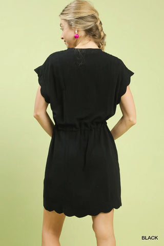 Woman wearing a black dress against a light green background