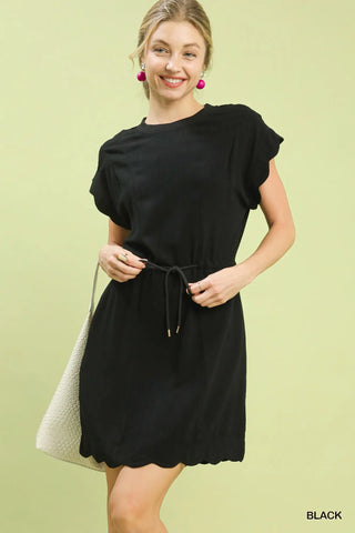 Woman wearing a black dress against a light green background