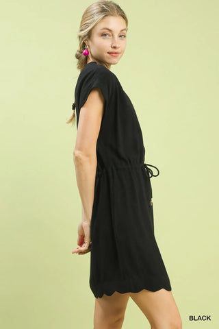 Woman wearing a black dress against a light green background