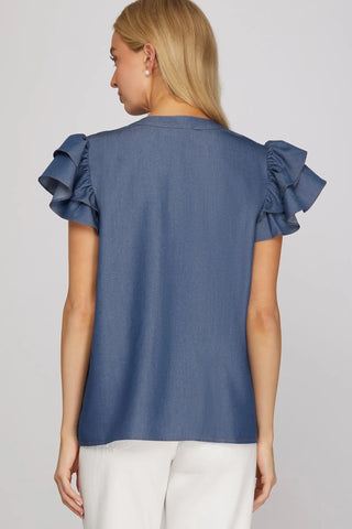 Woman wearing a blue denim blouse with ruffled sleeves from She & Sky rear view 